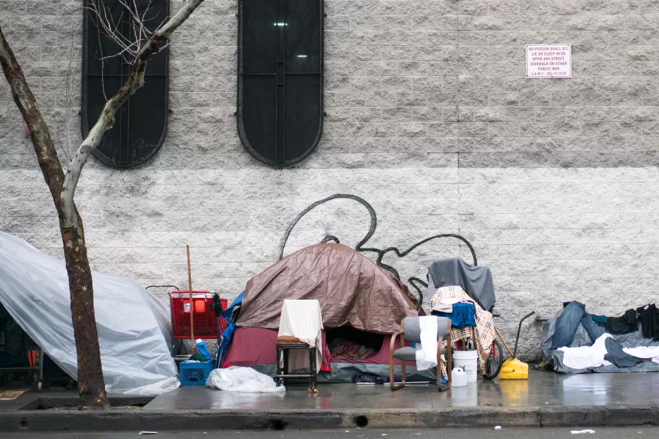 Tent covered with tarp with bike and other objects on sidewalk in Skid Row, downtown Los Angeles